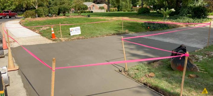Freshly poured concrete material for a concrete driveway construction in a residential area